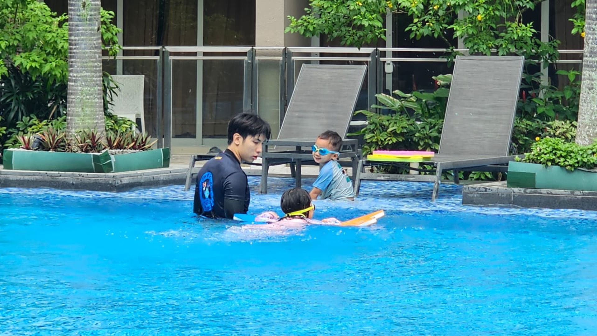 NROC certified swim coach teaching a young child a SwimSafer lesson in a Singapore condominium pool