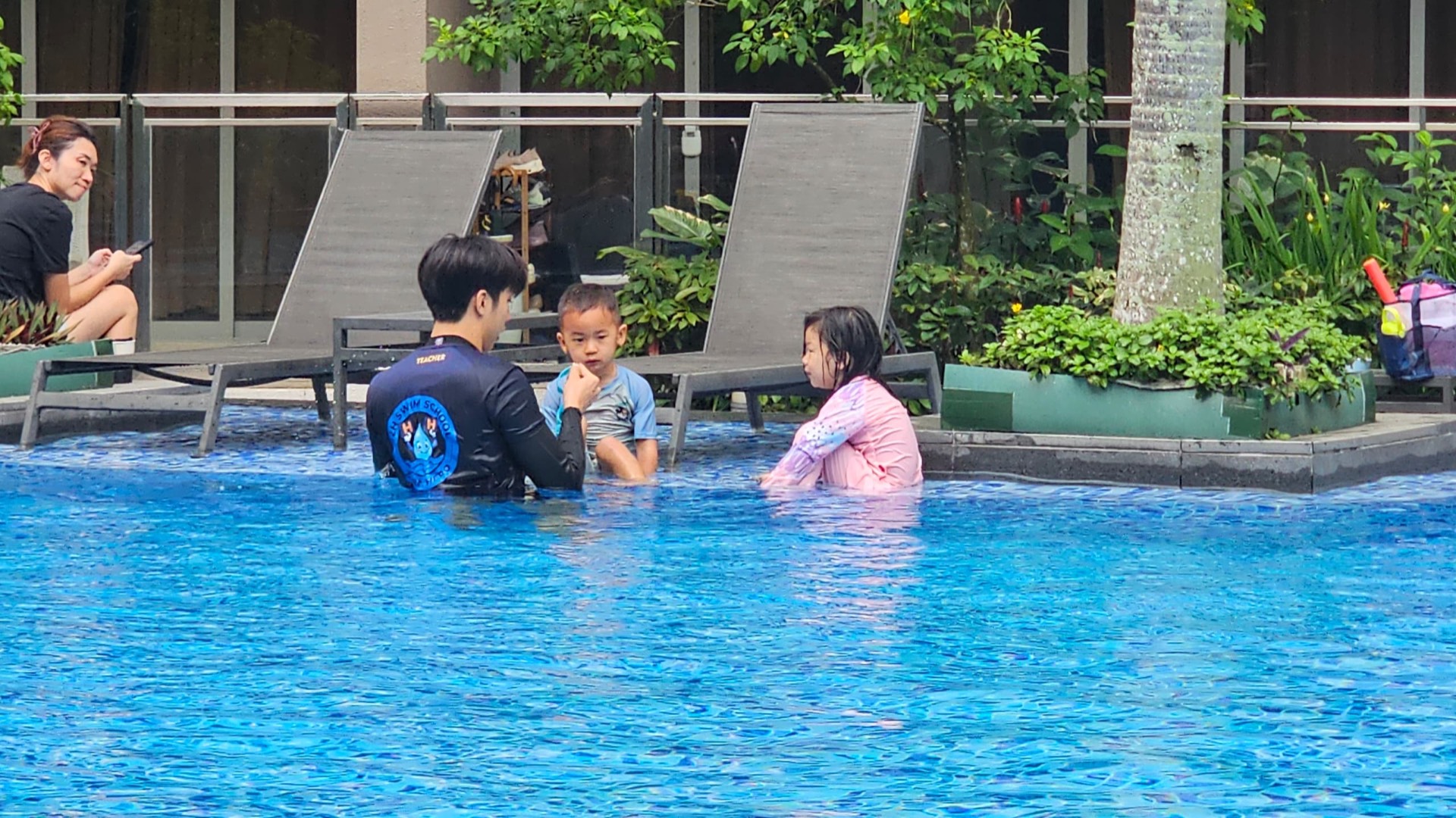 02H swim coach guiding a learn to swim lesson in an outdoor Singapore pool